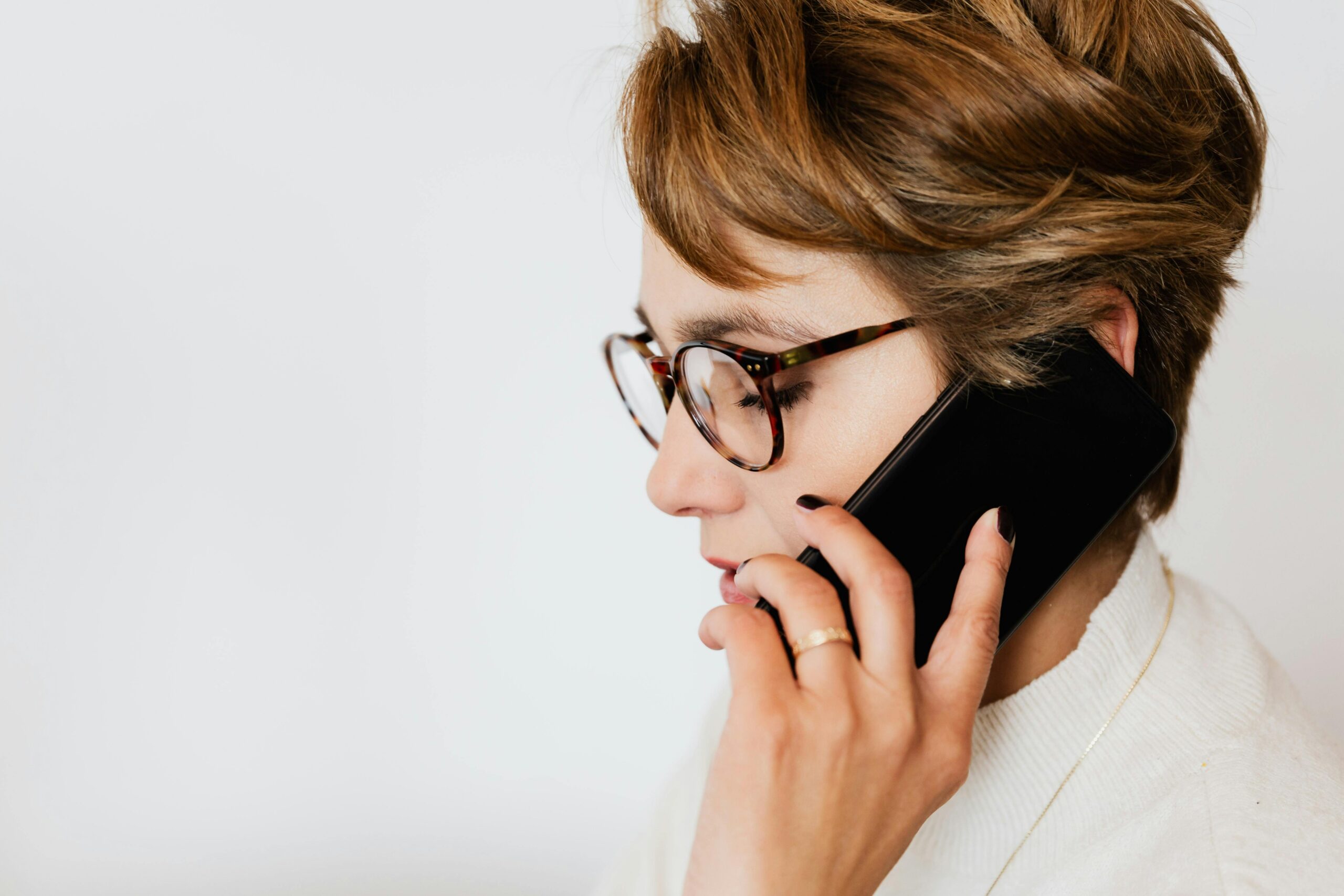 Thoughtful adult woman talking on smartphone